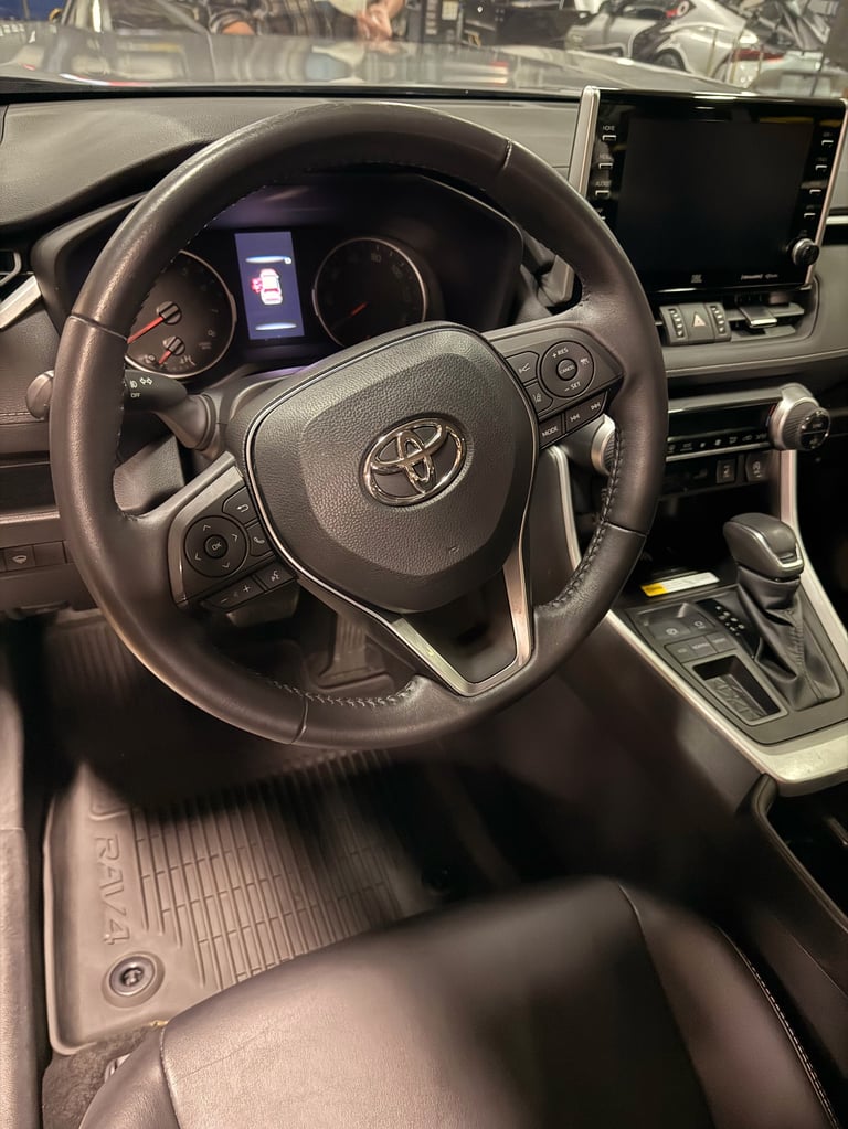 Toyota steering wheel and dashboard interior view with digital gauge cluster and touchscreen display