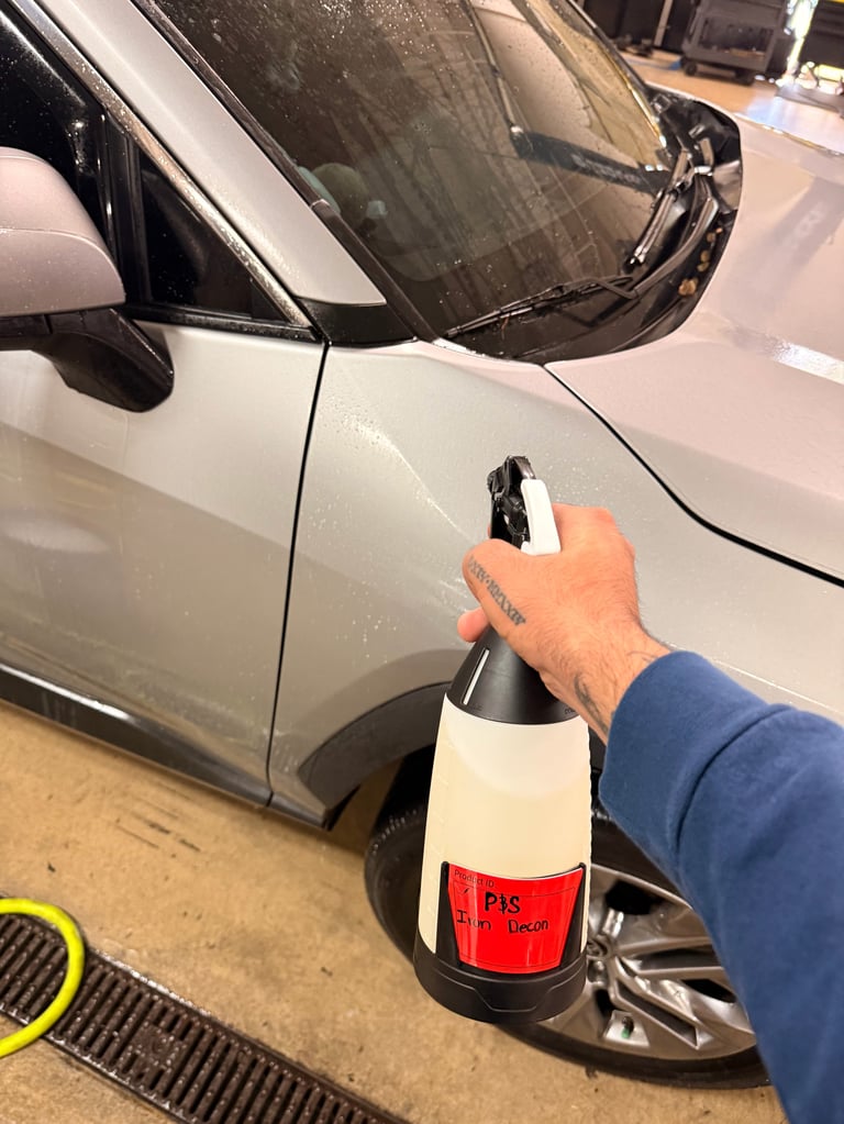 Person holding car door handle with reflective red and white safety sleeve near white vehicle in garage